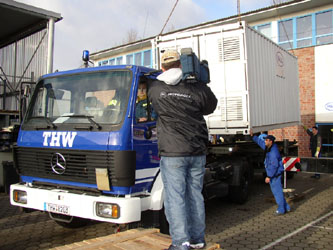 Die Verlastung des Containers mit der Trinkwasseraufbereitungsanlage wird von mehreren Fernsehteam im Film festgehalten. / Foto:Walter Piechatzek OV HH-Nord