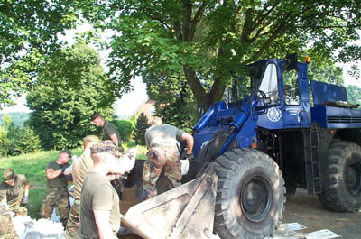 Foto: Benno Brunst OB Pasewalk / Soldaten entleeren die Sandscke in die Schaufel des THW-Radladers
